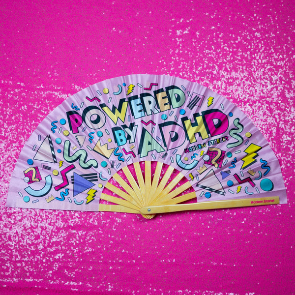 Powered by ADHD bamboo clack fan by Harlem Starlet, a bold neurodivergent statement hand fan perfect for Pride festivals, raves, queer events and ADHD babes who love funny statement fans.