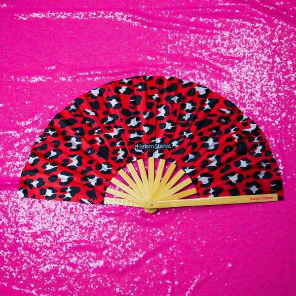 Red leopard print bamboo clack fan with bold pink and black pattern. Large folding festival hand fan perfect for Pride, doofs, festivals, weddings, raves, drag shows and queer nightlife.