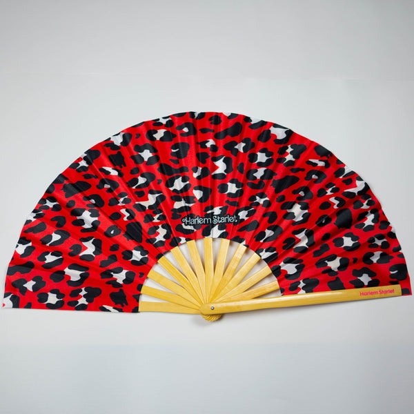 Red leopard print bamboo clack fan with bold pink and black pattern. Large folding festival hand fan perfect for Pride, doofs, festivals, weddings, raves, drag shows and queer nightlife.
